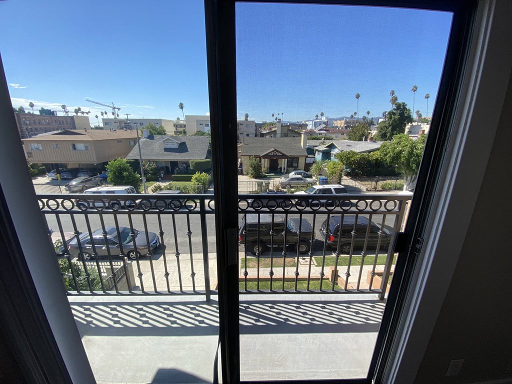 a balcony with a view of a parking lot and a city
