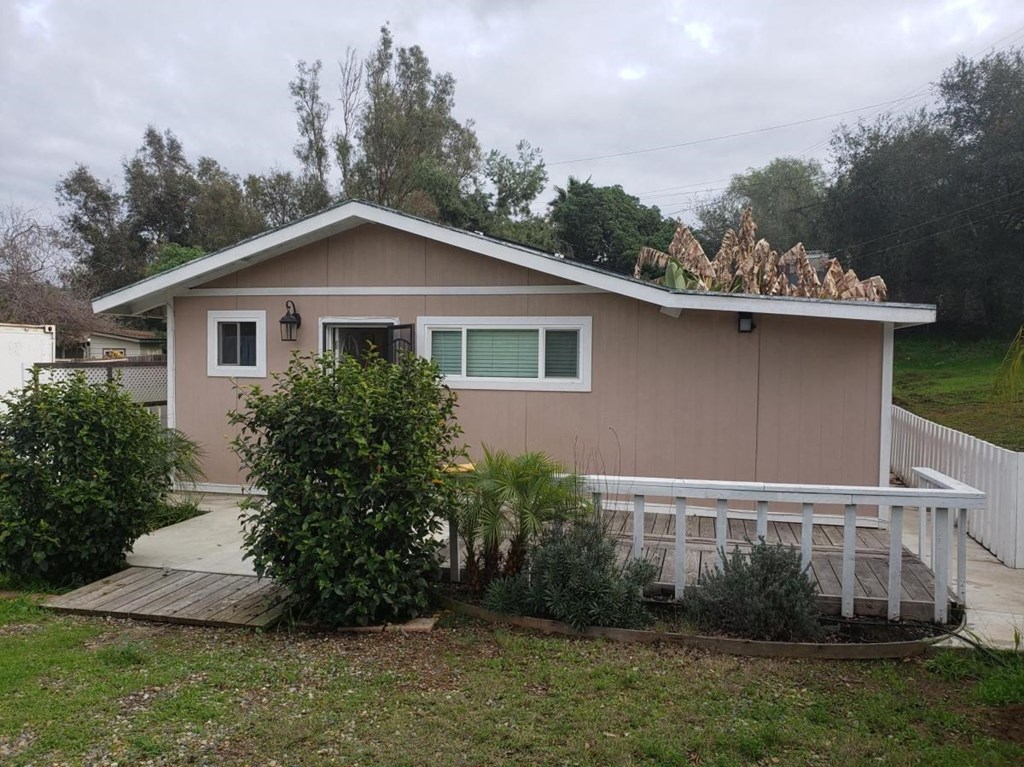 a small pink house with a porch and a deck