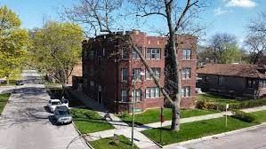 an aerial view of a red brick building on a street