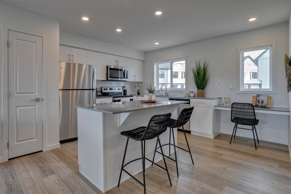 an open kitchen with an island and two bar stools