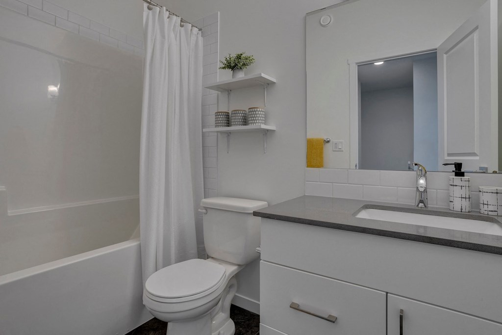 a bathroom with a toilet and a sink and a shower