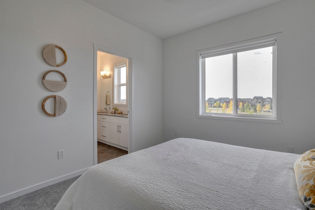 a bedroom with a bed and a window and a bathroom