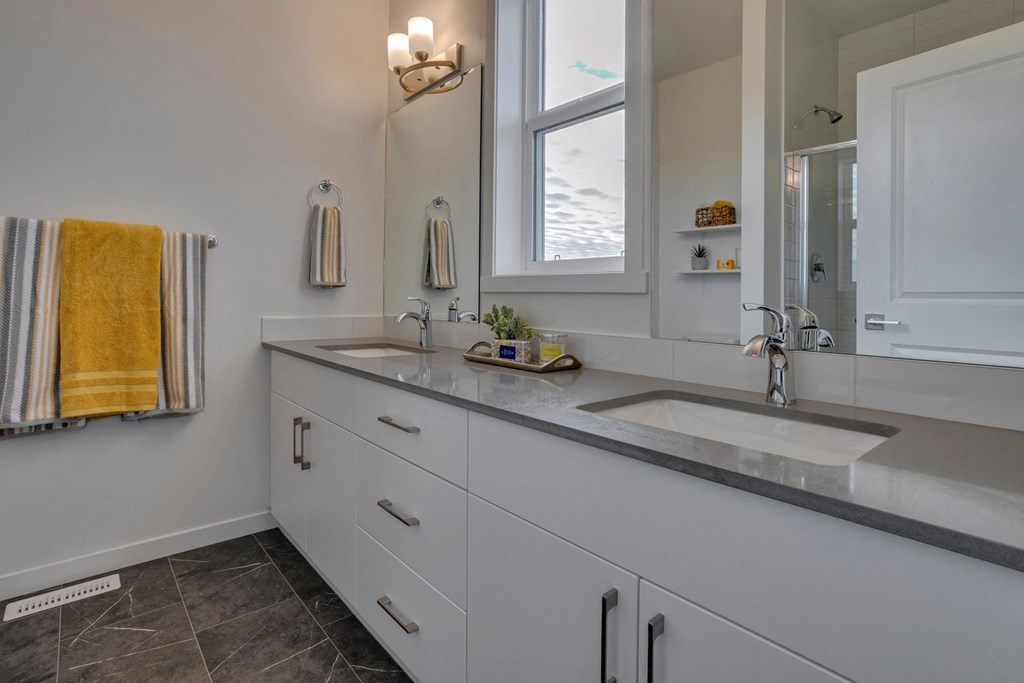 a white bathroom with two sinks and a mirror