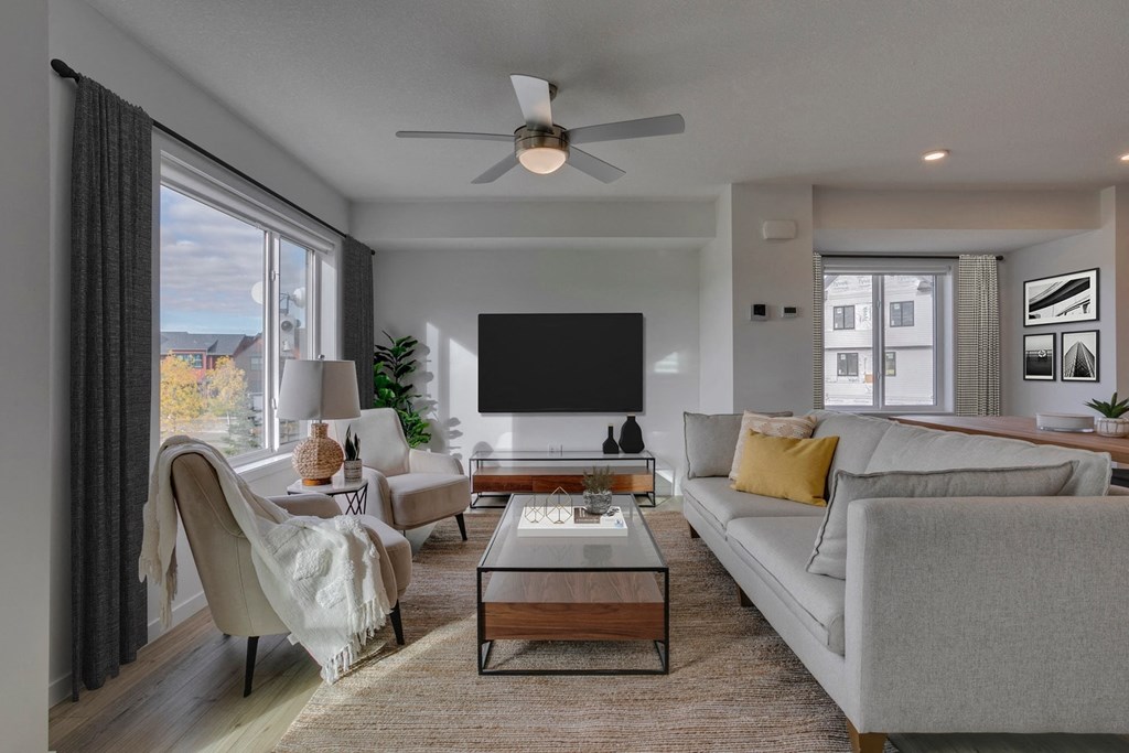 a living room with a couch and a table and a ceiling fan