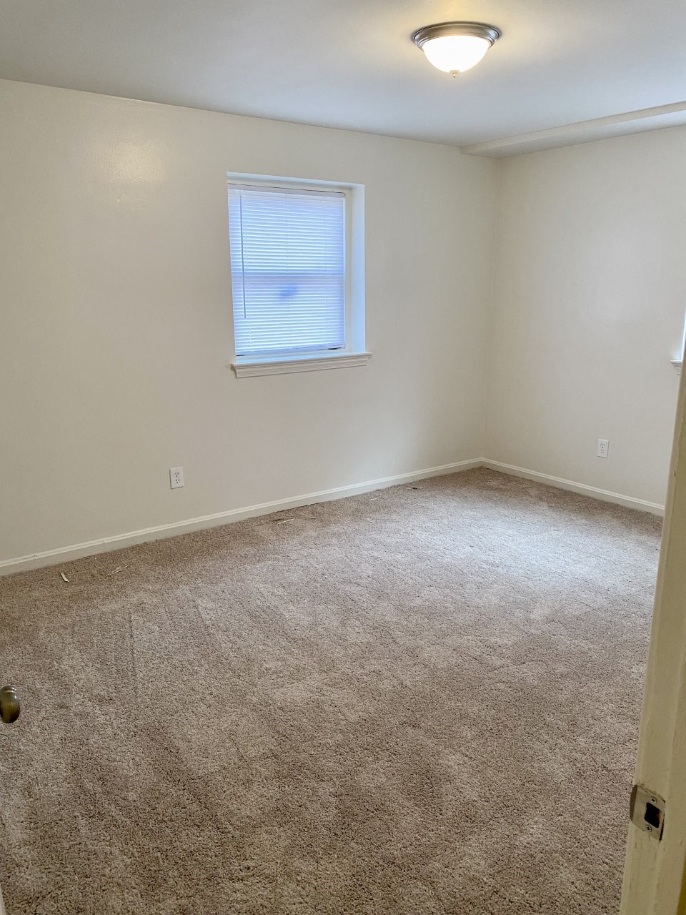 an empty room with carpet and a window