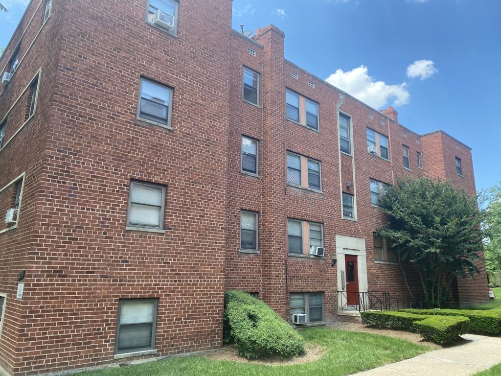 a brick building with a sidewalk in front of it
