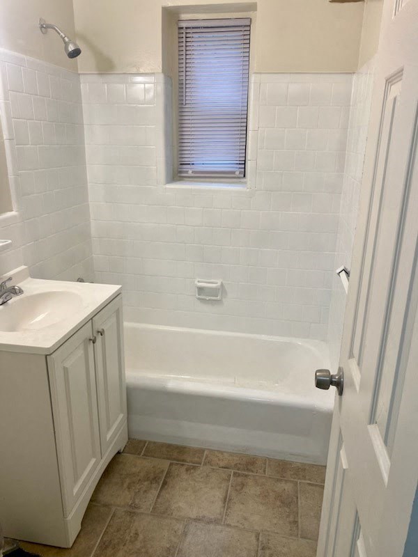 a bathroom with a tub and a sink and a window