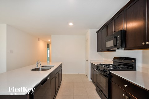 A kitchen with black cabinets and a white counter top.