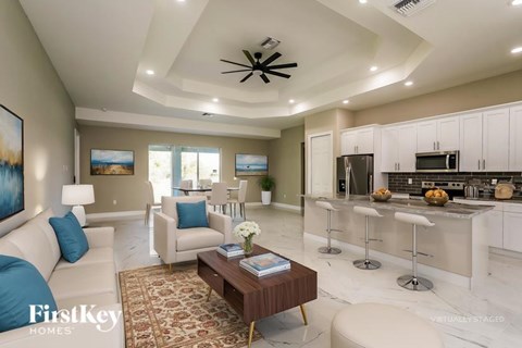 A modern living room with a large painting on the wall and a coffee table in the center.