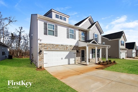 A modern two-story house with a garage is showcased in the image.