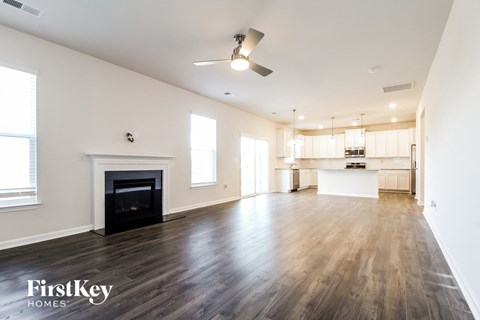 A spacious living room with a fireplace and wooden floors.