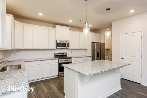 A kitchen with white cabinets and a granite countertop.