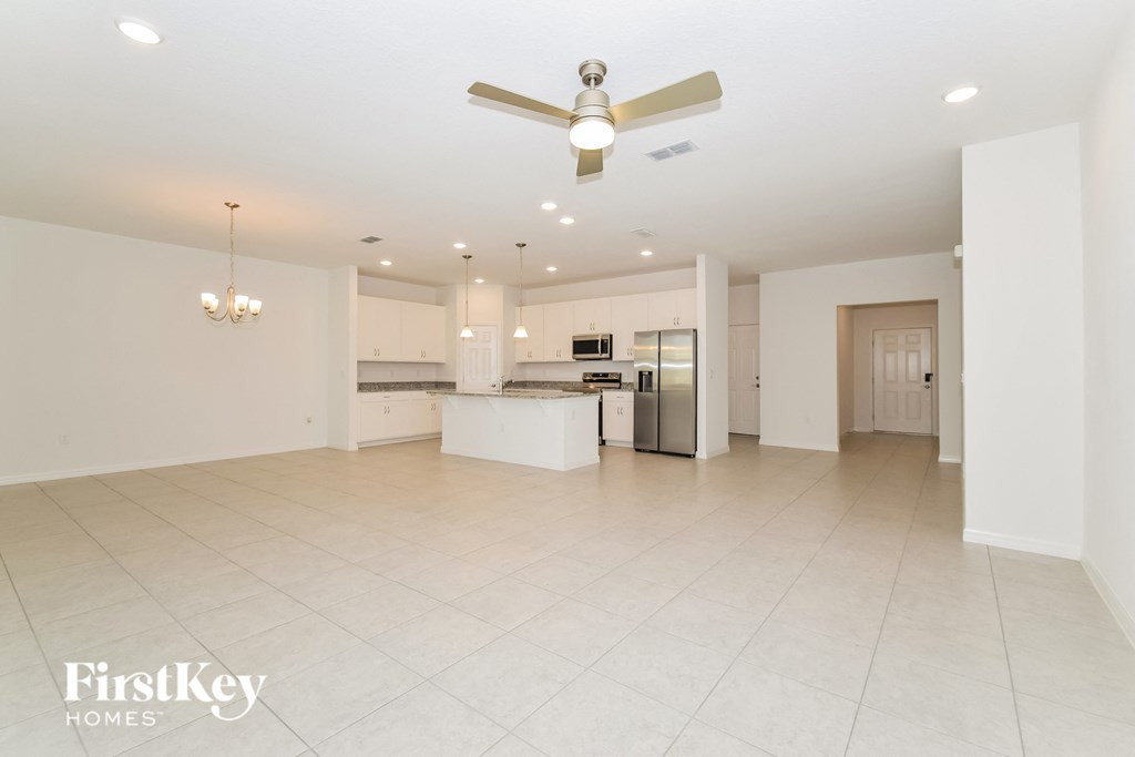 an open kitchen and living room with a ceiling fan