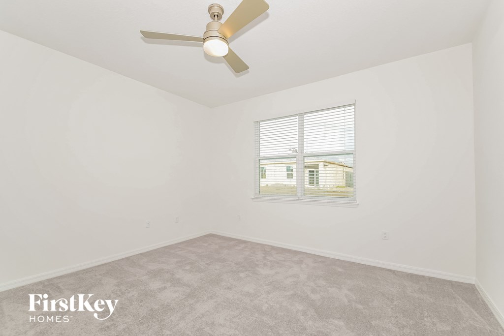 the living room of a home with a ceiling fan and a window