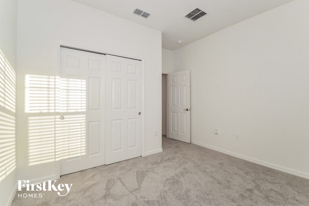 a bedroom with white walls and white doors and a carpeted floor