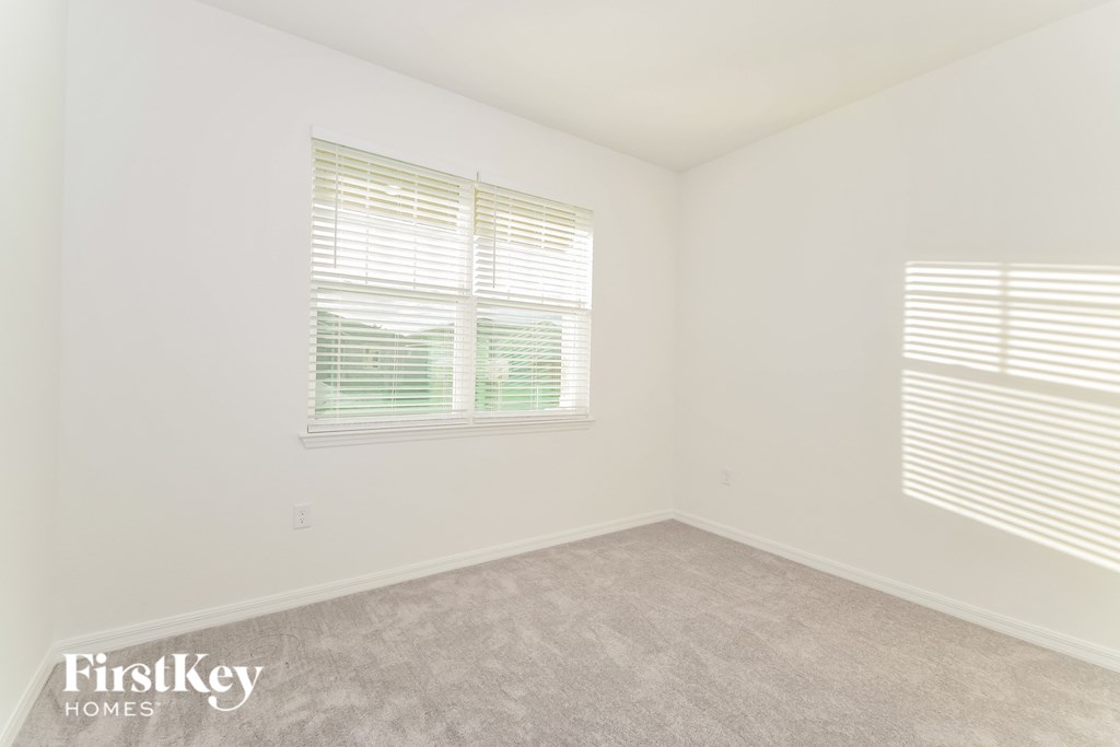 a bedroom with a carpeted floor and two windows