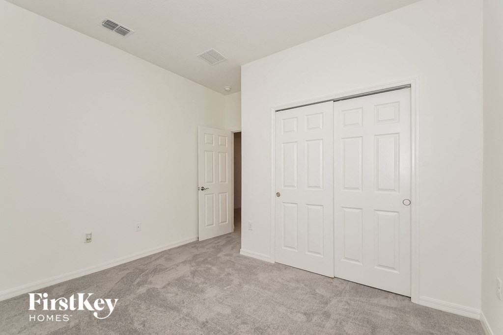 the living room of a home with white walls and white doors