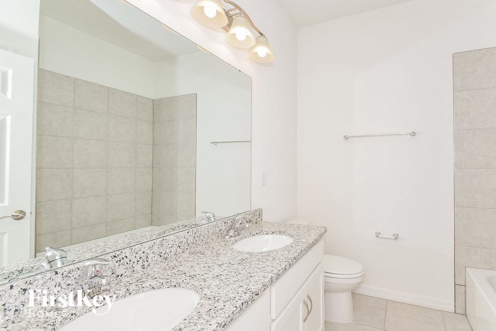 a bathroom with two sinks and a mirror and a toilet