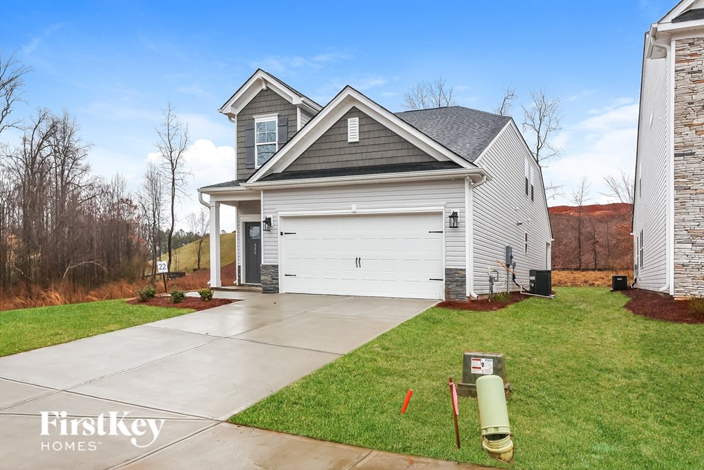 A house with a garage and a driveway in front of it.