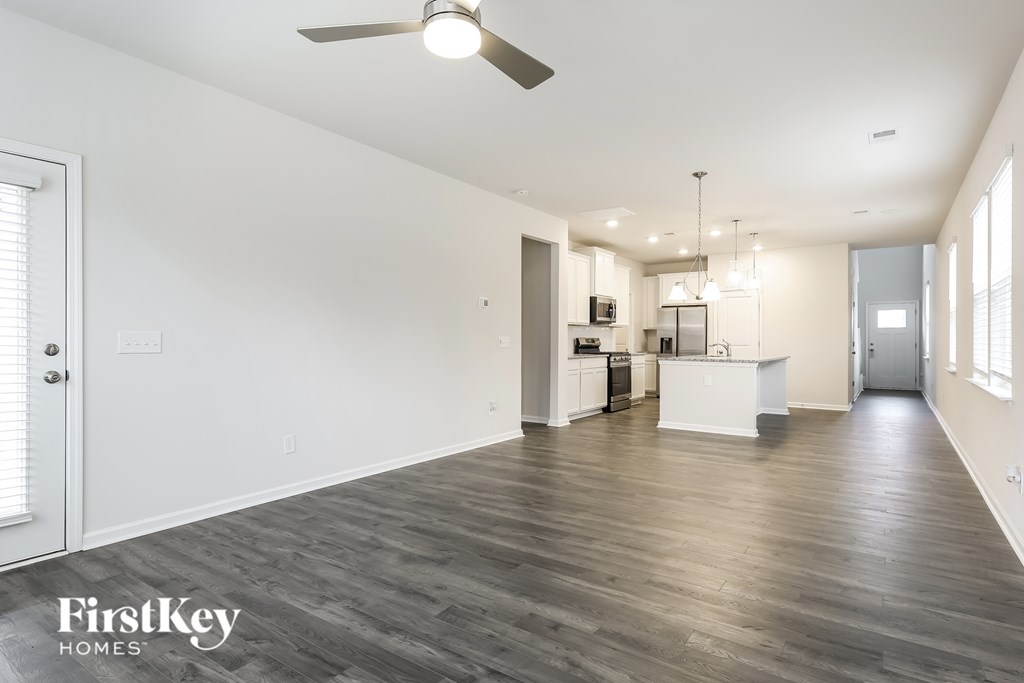 A spacious room with a ceiling fan and wooden flooring.