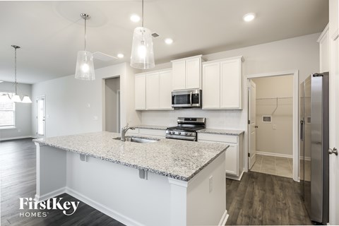 A kitchen with a granite countertop and white cabinets.