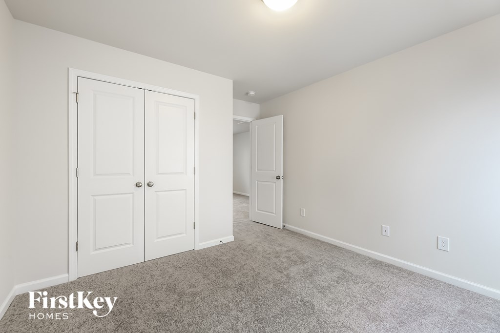 A room with two doors and a carpeted floor.