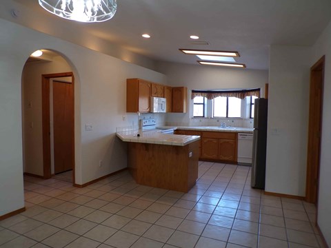 A kitchen with a sink, stove, and refrigerator.