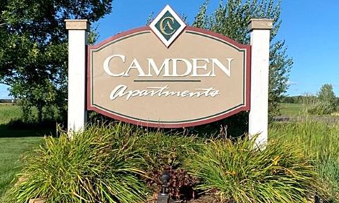 a sign for a campen apartments sign in the grass