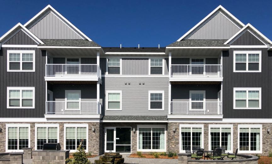 a large apartment building with a patio in front of it
