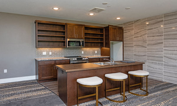 a kitchen with a counter and three stools