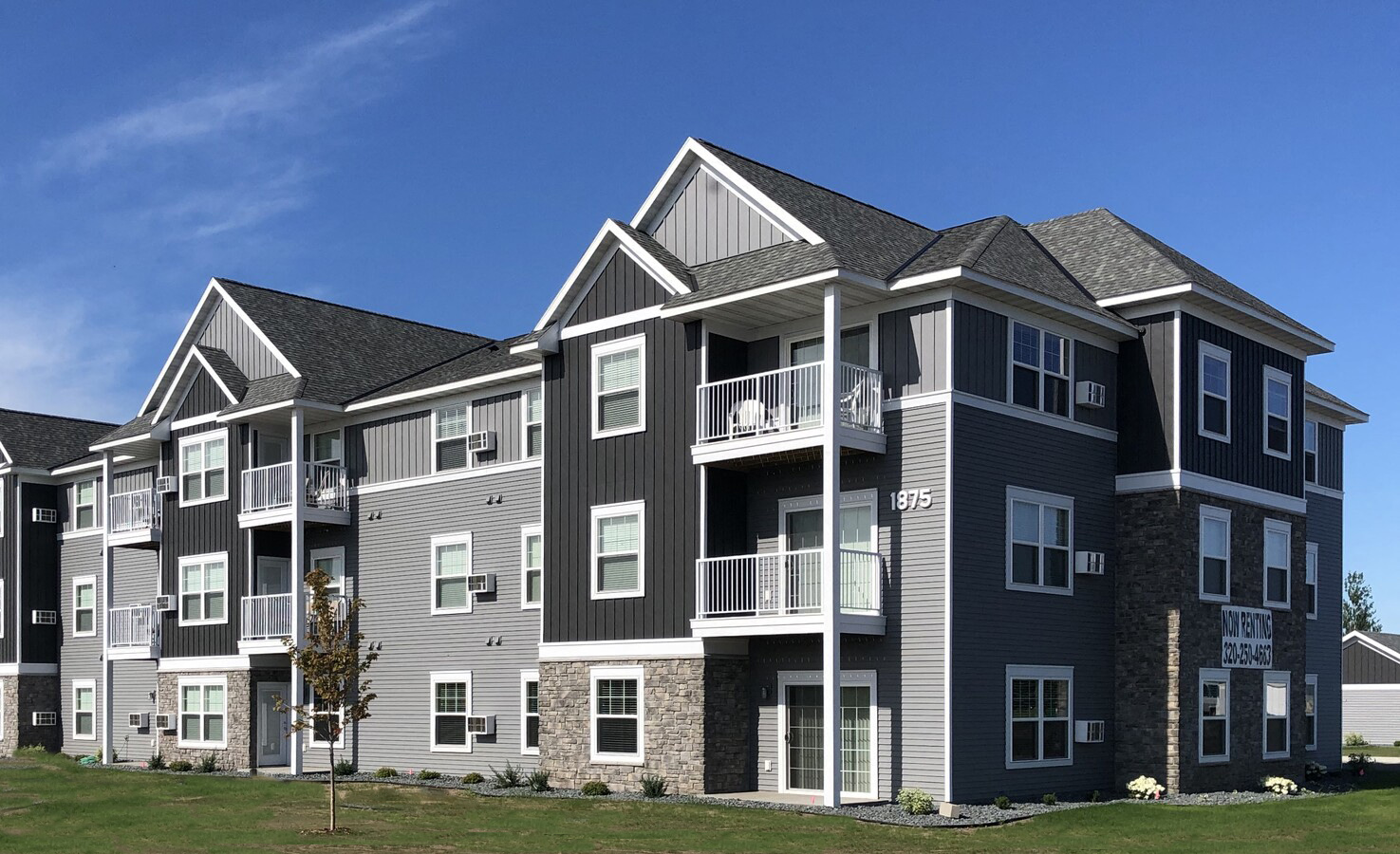 a large apartment building with a blue sky in the background