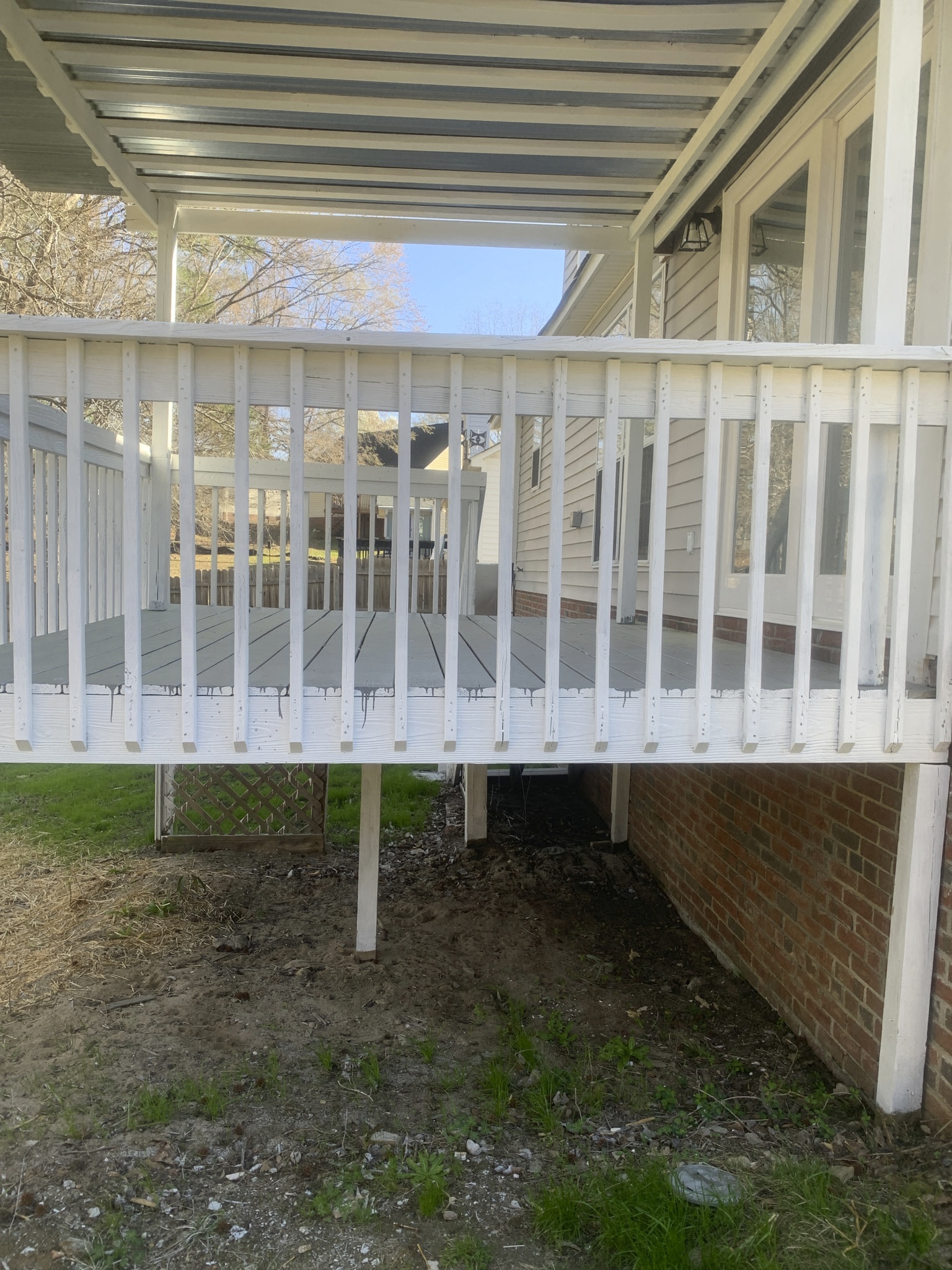 a porch with a white fence on the side of a house