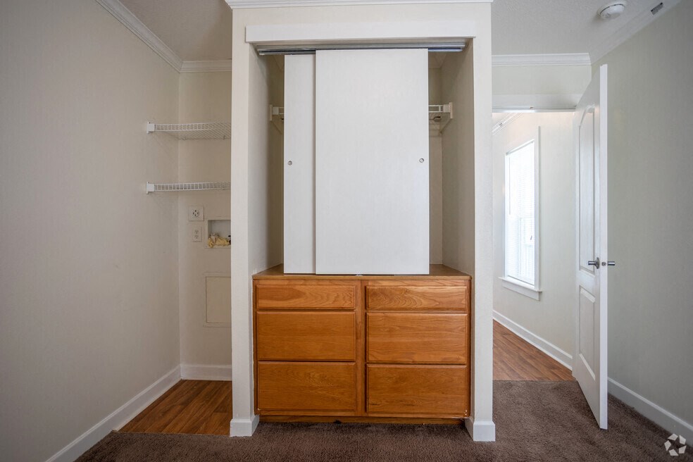 a bedroom with a dresser and a closet