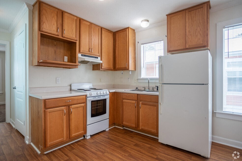 an empty kitchen with wooden cabinets and white appliances