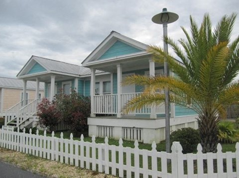 a blue and white house with a white picket fence