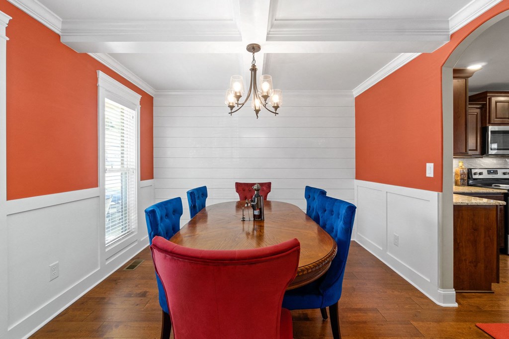 a dining room with red chairs and a wooden table