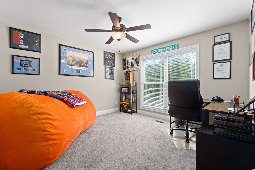 a bedroom with an orange bed and a ceiling fan