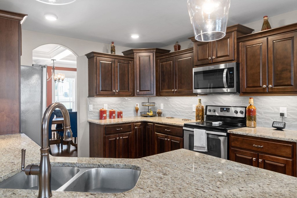 a kitchen with wooden cabinets and granite counter tops and a sink