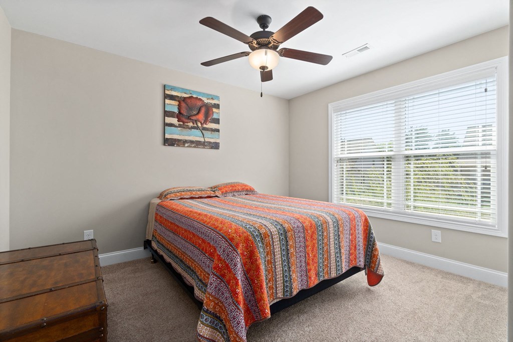 a bedroom with a bed and a ceiling fan