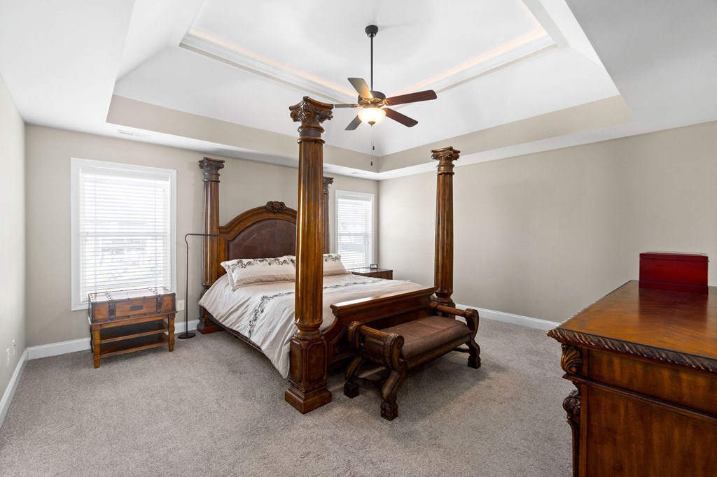 a bedroom with a four poster bed and a ceiling fan