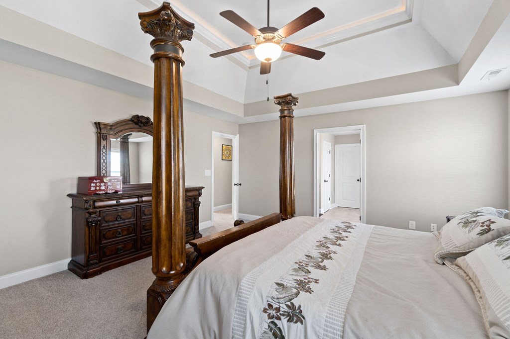 a bedroom with a large bed and a ceiling fan