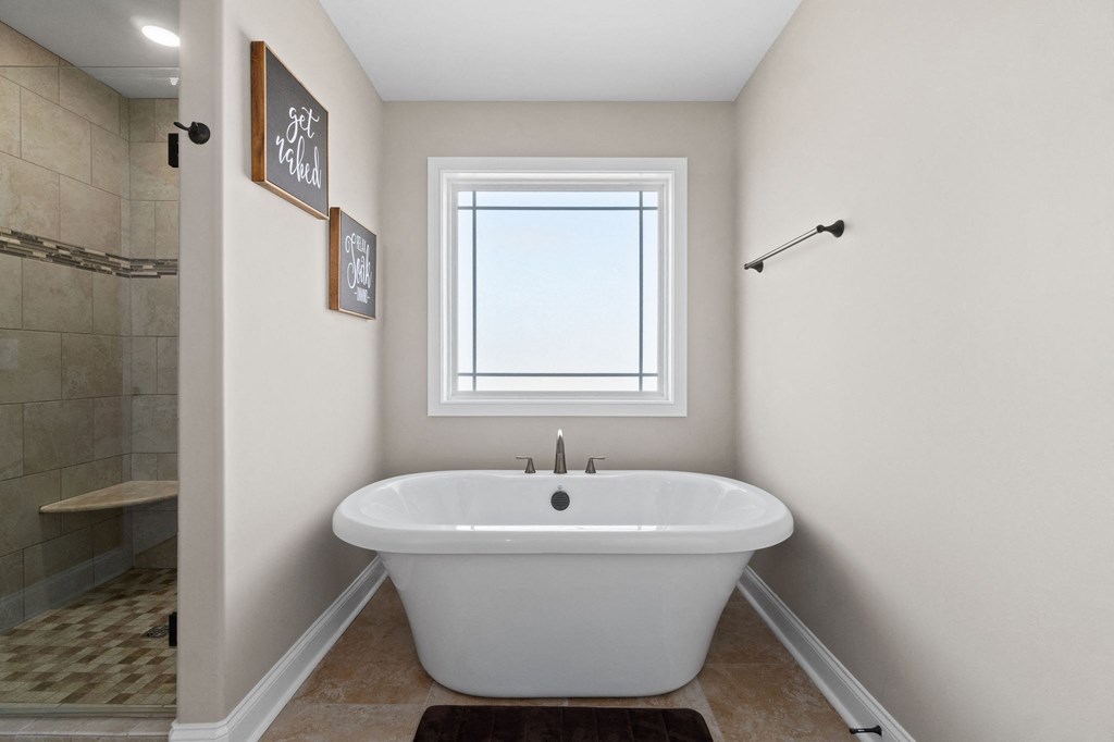 a bathroom with a tub and a shower and a window