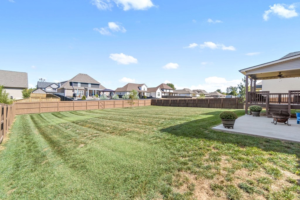 the backyard of a house with a fence and a lawn