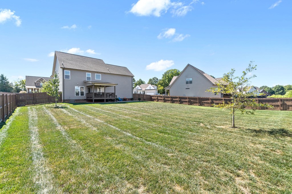the backyard of a house with a yard and a fence