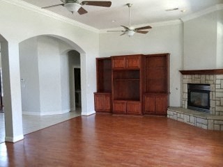 an empty living room with a fireplace and wooden floors