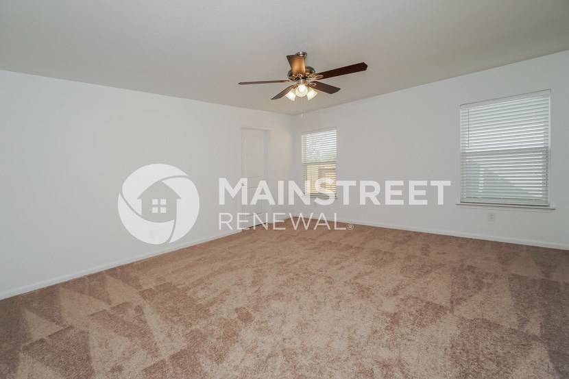 a large living room with a ceiling fan