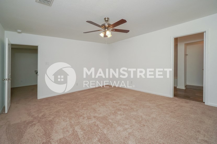 a bedroom apartment with a living room and a ceiling fan