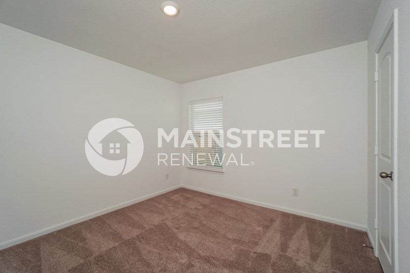 a room with a carpeted floor and a white door