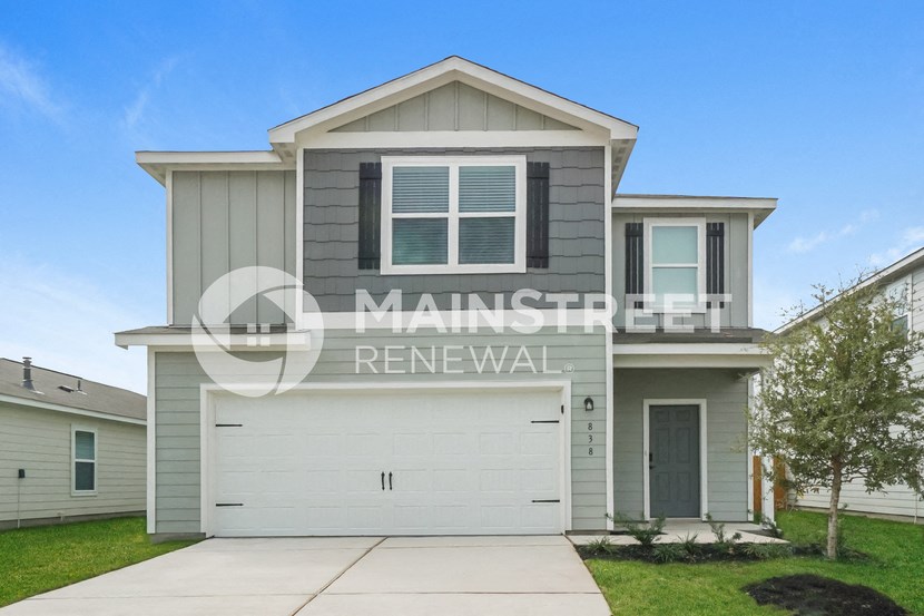 a renovated house with a garage and a lawn