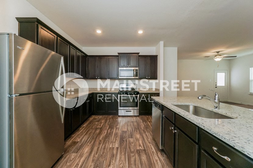 a kitchen with marble countertops and stainless steel appliances